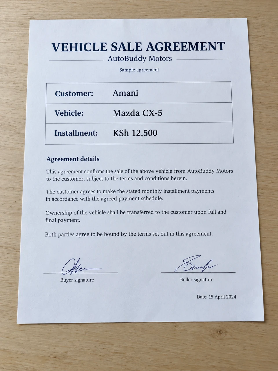 Sample paper vehicle sale agreement photographed on a desk: Amani, Mazda CX-5, installment KSh 12,500.